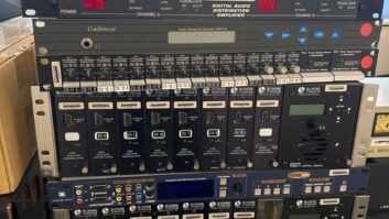 A stack of assorted older broadcast and audiovisual devices on a desk