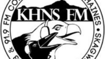 Round logo of KHNS showing a cartoon of an eagle and a crow, both wearing headphones