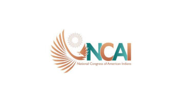 Logo of the National Congress of American Indians with the letters NCAI superimposed on a stylized eagle with a stylized sun in the background