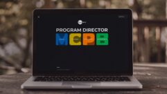 A computer laptop, with the logo of Super Hi-Fi's Program Director visible on the screen. The letters MCPB are in bright colors, and labeled Music, Content, Programs, Broadcast.