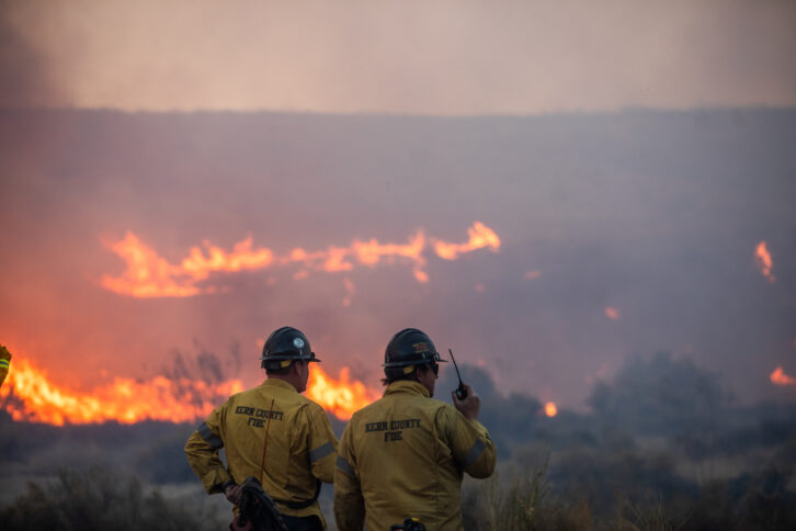 Firefighters are silhouetted by flames from the Hughes Fire in northwest Los Angeles County in January. Credit: APU GOMES/AFP via Getty Images 